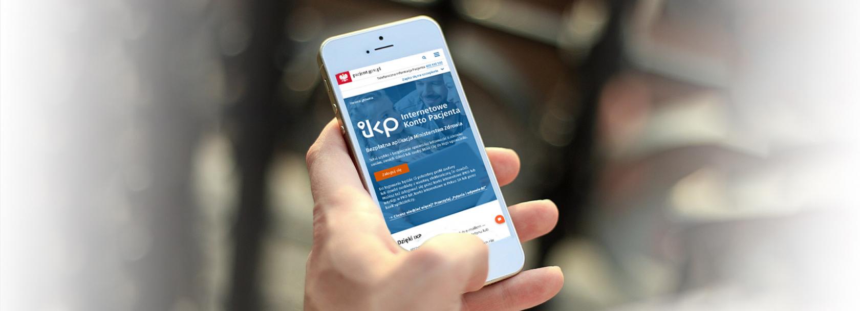 Telefon komorkowy trzymany w dłoni. Na ekranie wyświetlone IKP