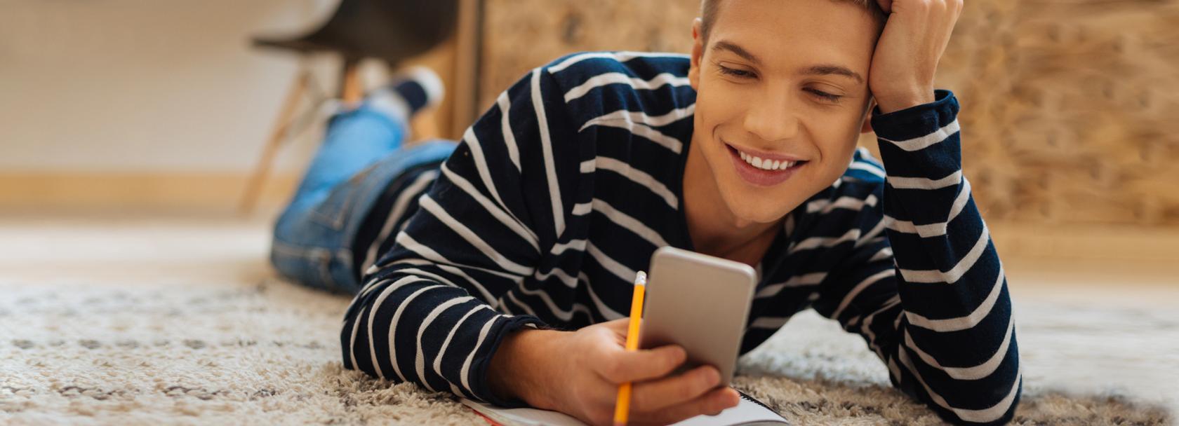 Młody mężczyzna patrzy na komórkę