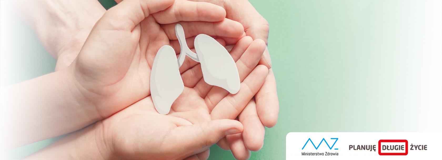 Model płuc trzymany w dłoniach, które są podtrzymywane przez większe dłonie.