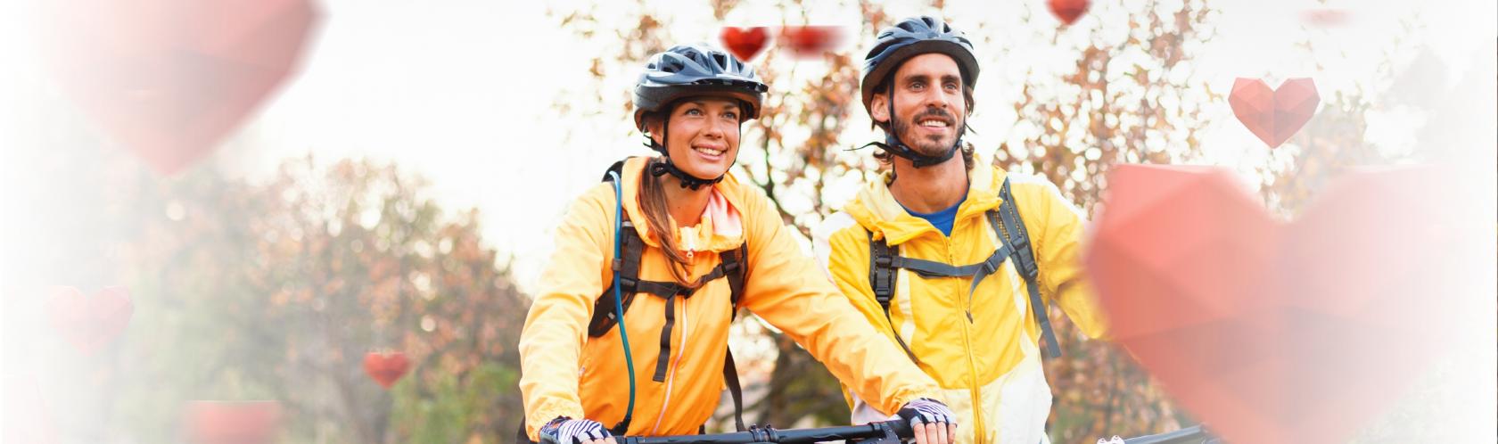 Para młodych ludzi na rowerach. Na głowach mają kaski. 