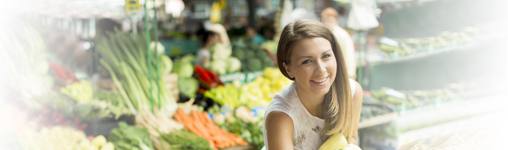 Kobieta wybierająca warzywa na targu warzywnym