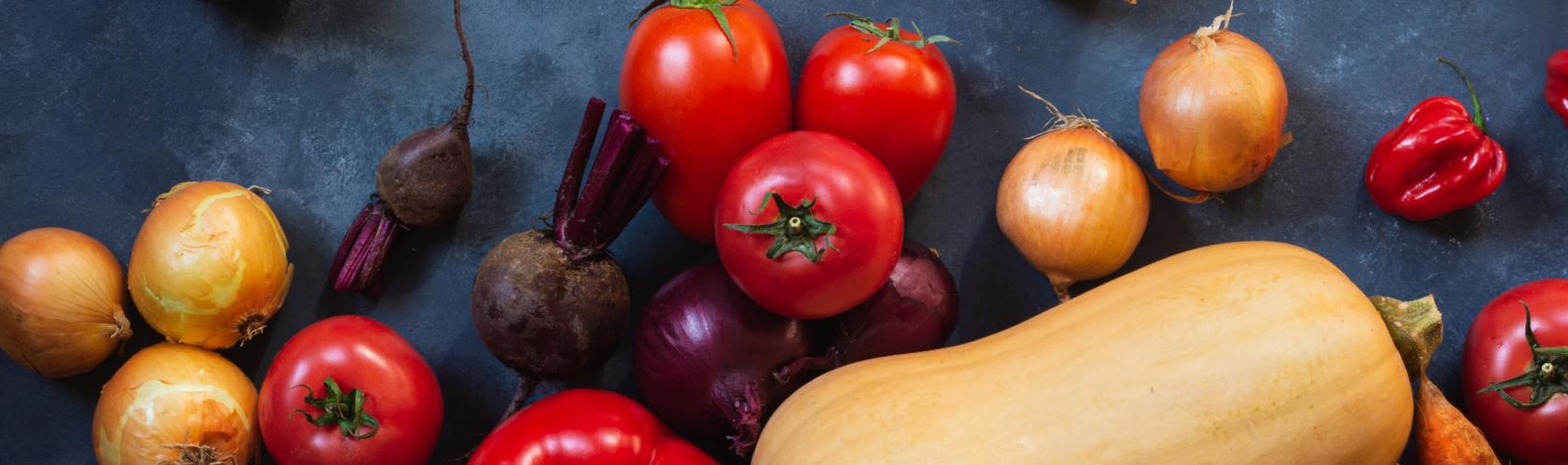 Warywa leżące na stole - m.in. dynie, pomidory, papryki, cebule