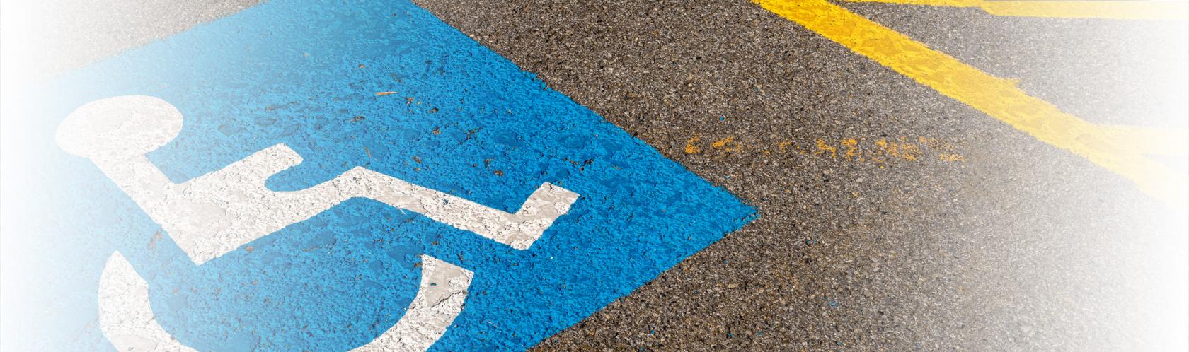 Oznaczenie miejsca do parkowania dla osoby z niepełnosprawnościa i inwalidy - wózek na niebieskim tle