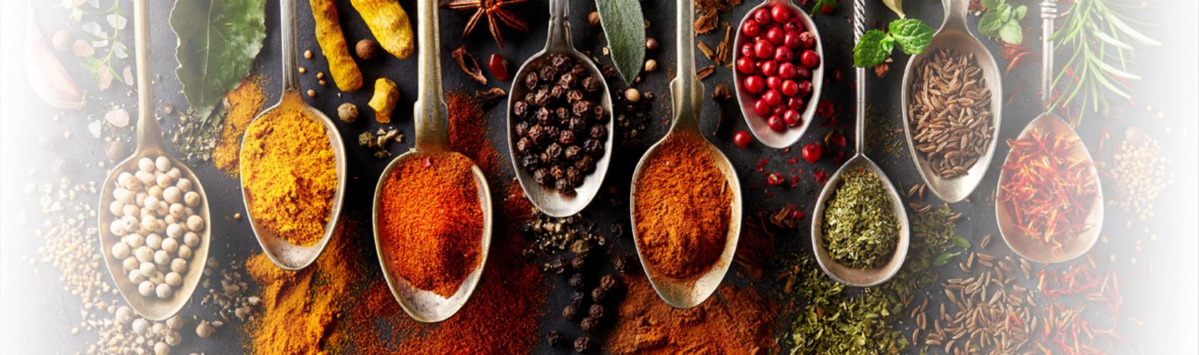 Leżące łyżki zapełnione różnymi kolorowymi przyprawami.