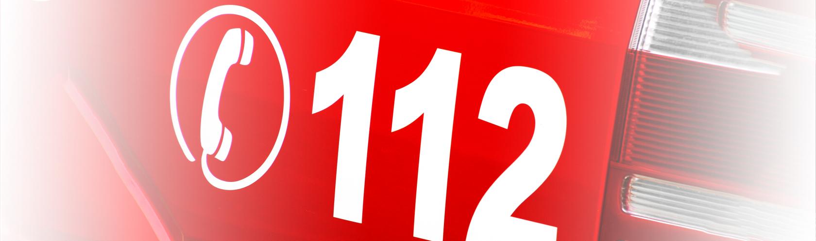 fragment czerwonego pojazu z numerem  112 i słuchawką 
