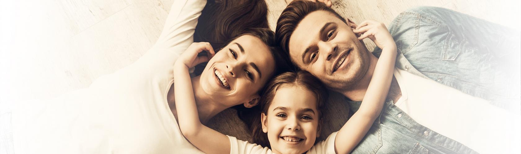 :eża rodzice i dziecko w środku. Dziecko obejmuje rodziców za szyję. Zdjecie tylko na głowy i ramiona, zrobione z rzutu ptaka