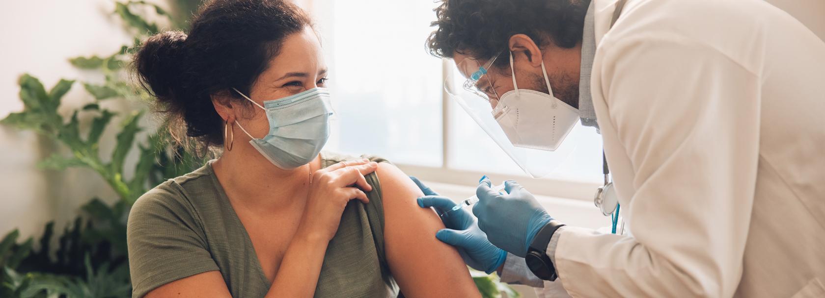 szczepienie młodej kobiety przez brodatego pielęgniarza