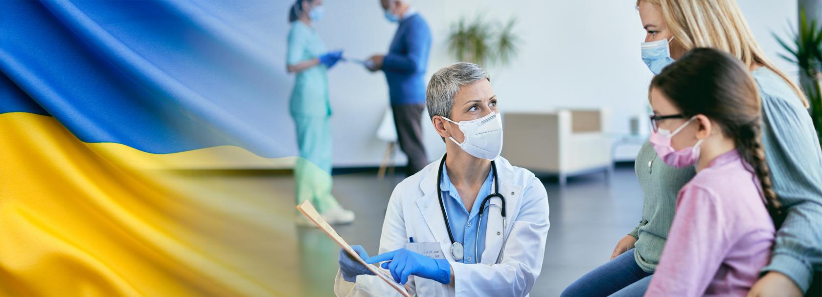 Lekarz pokazuje kartę matce z dzieckiem, flaga ukraińska po lewej