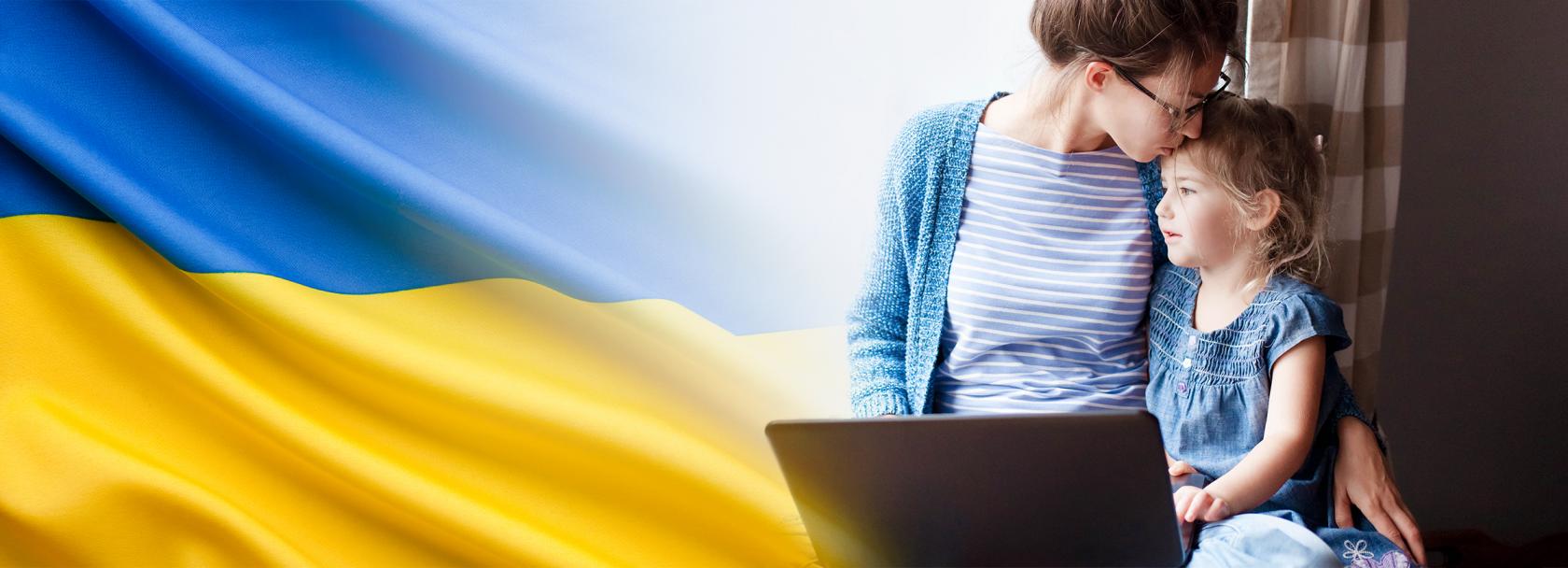 Matka przed komputerem całuje malucha w głowę