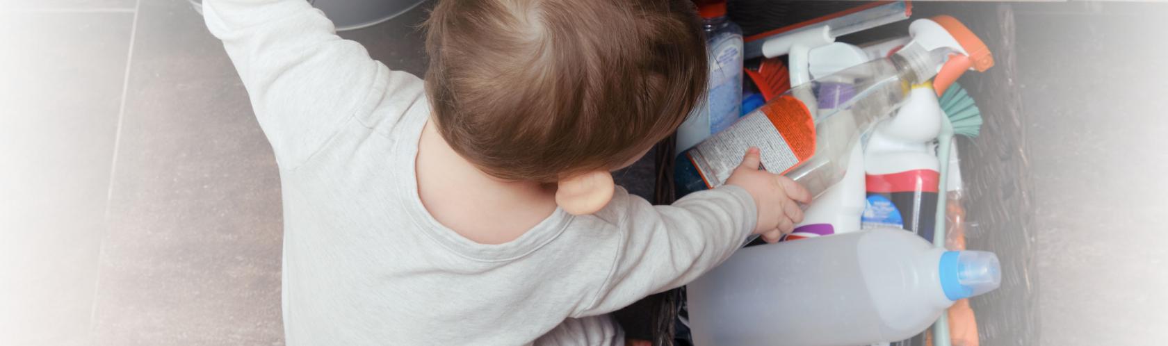 Bobas w łazience bawi się detergentami w koszyku. 