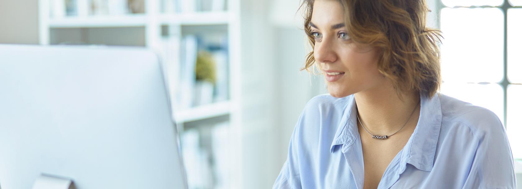 uśmiechnięta dziewczyna przed kompem