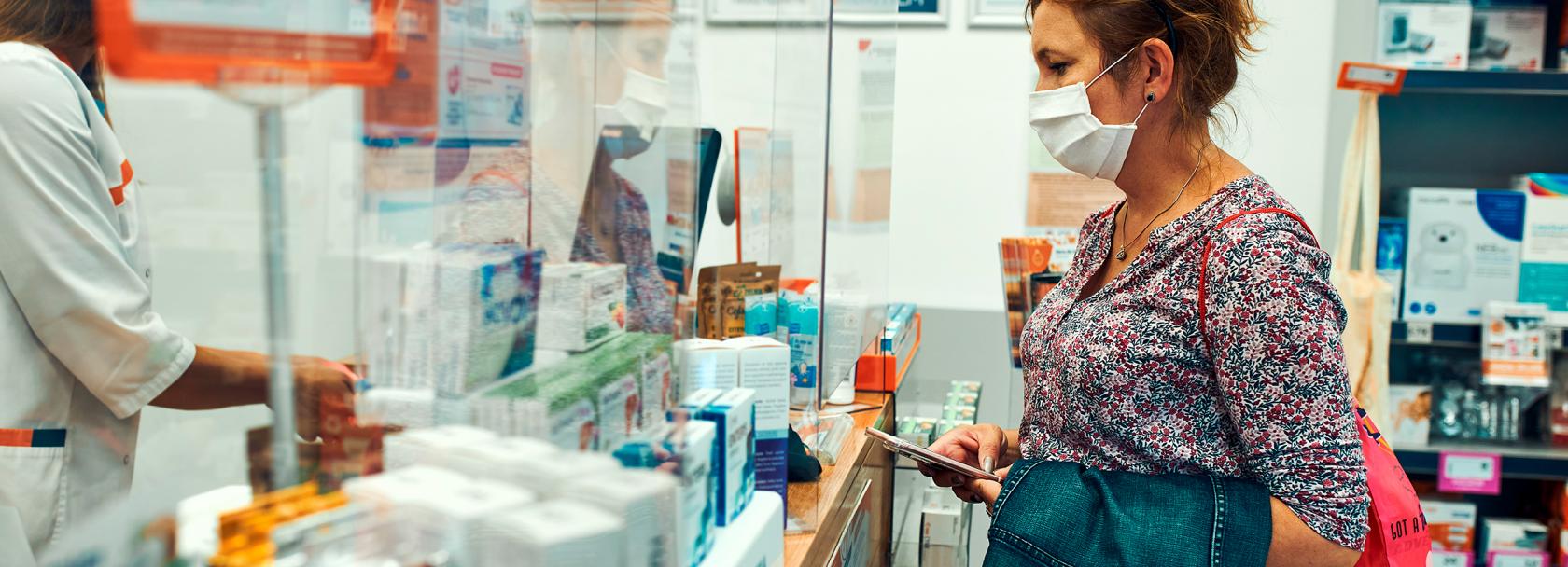kobieta z komórką w aptece