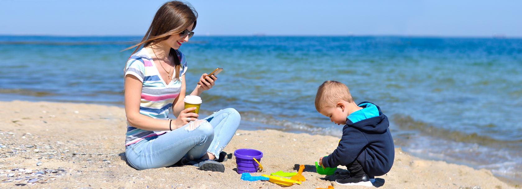 Matka z komórka, chłopiec, plaża
