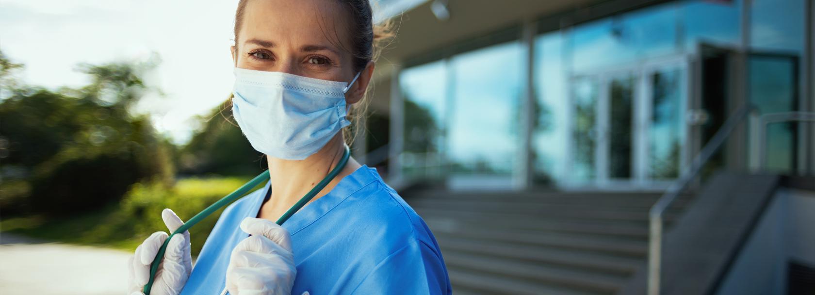 kobieta w maseczce, niebieskim kitlu i ze stetoskopem