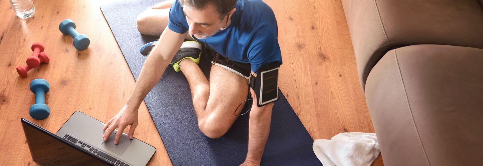 mężczyzna siedzi na podłodze z laptopem