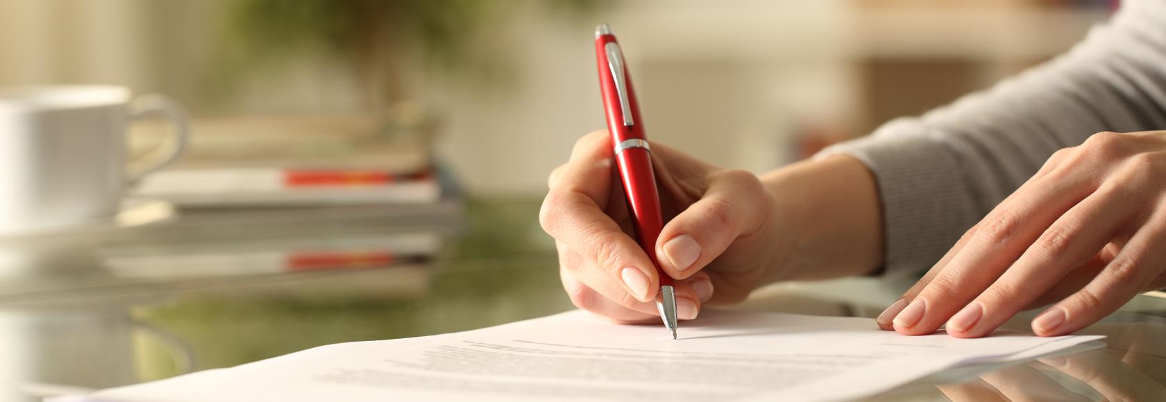 Damskie dłonie wypełniają formularz.