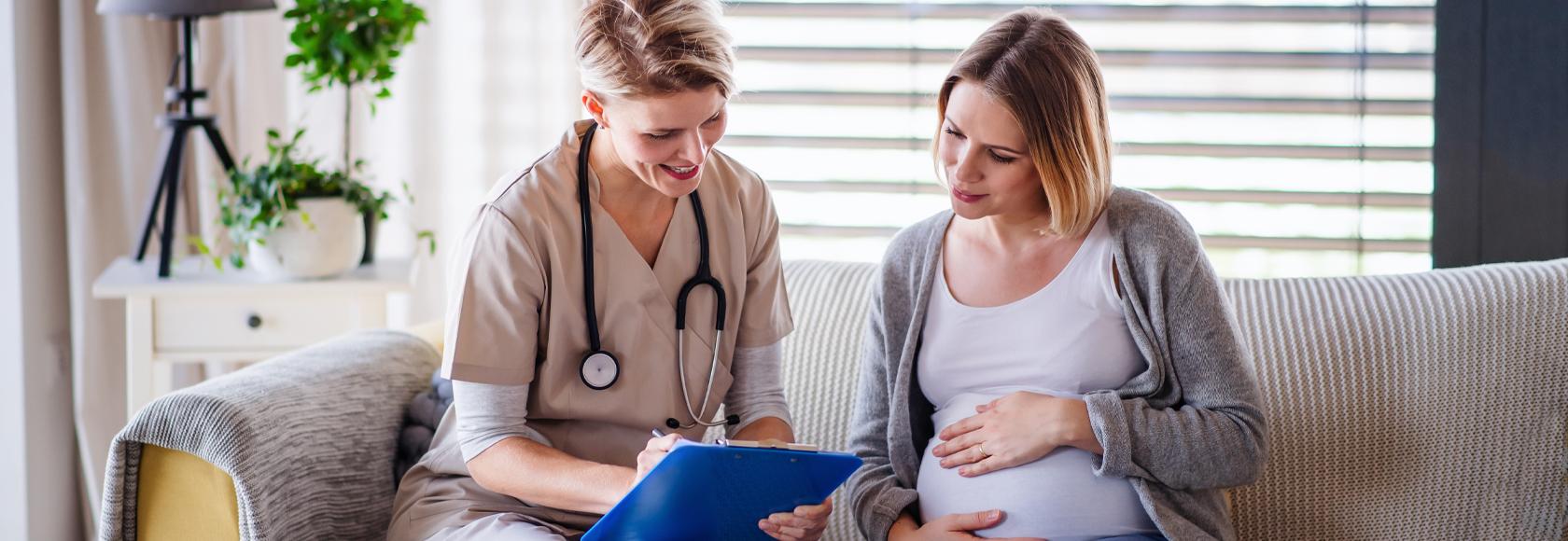 Położna podczas wizyty domowej u pacjentki w zaawansowanej ciąży. Omawiają wyniki badań.