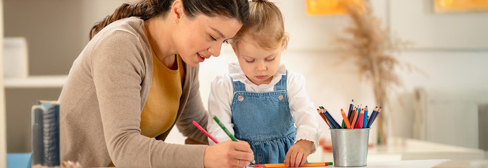 Kobieta rysuje z dziewczynką.
