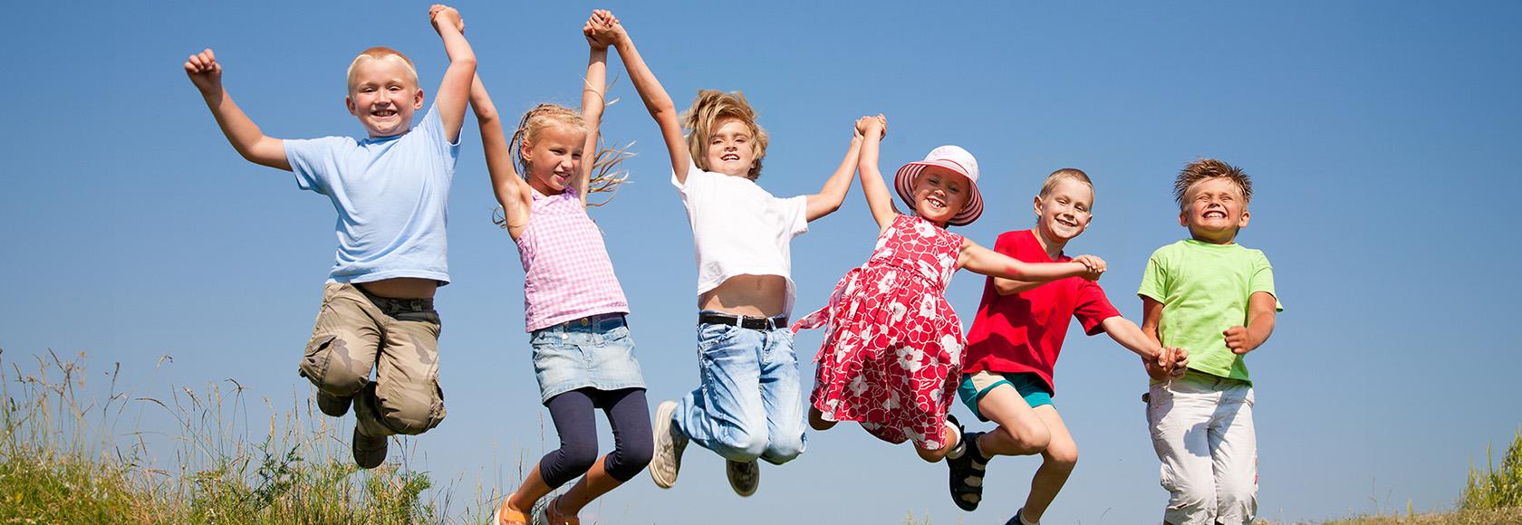 dzieci radośnie skaczą na łące