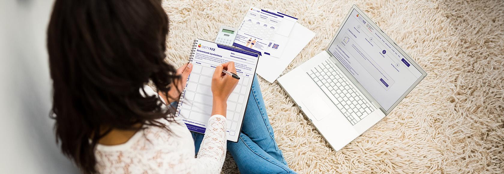 kobieta pisze w dzienniczku żywieniowym