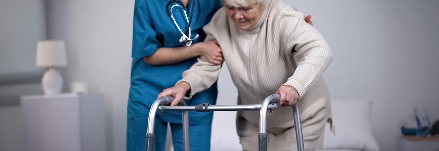 starsza kobieta idzie z chodzikiem