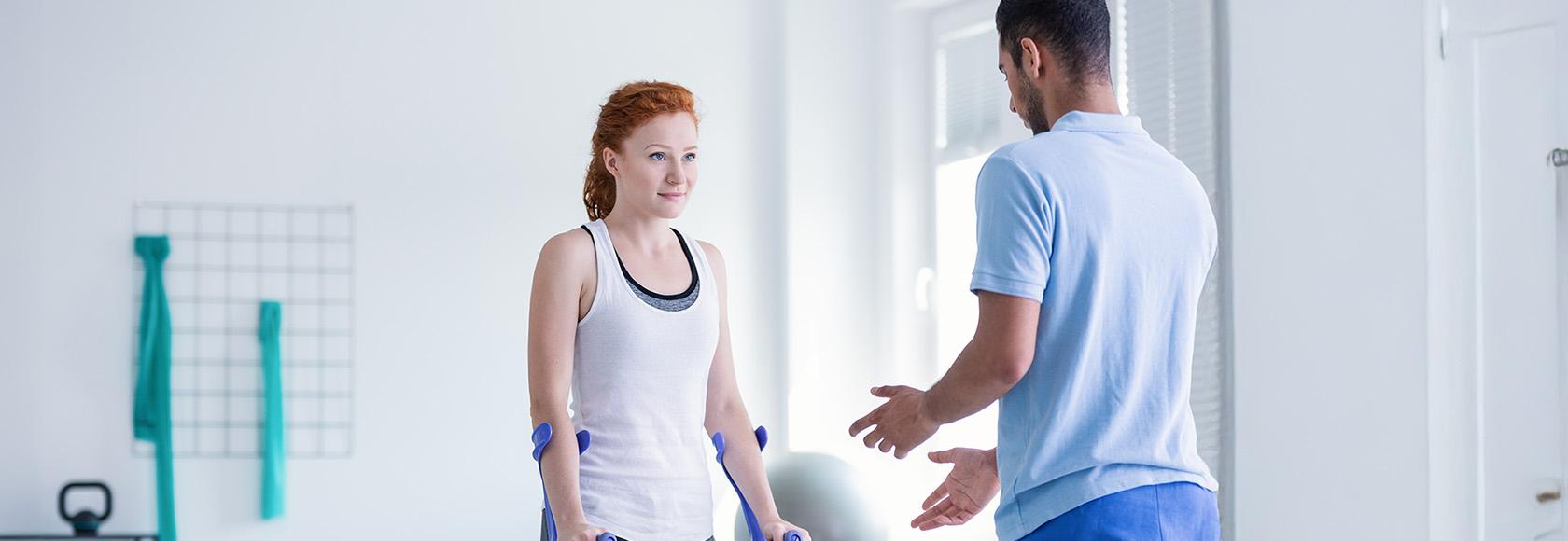 kobieta o kulach rozmawia z fizjoterapeutą