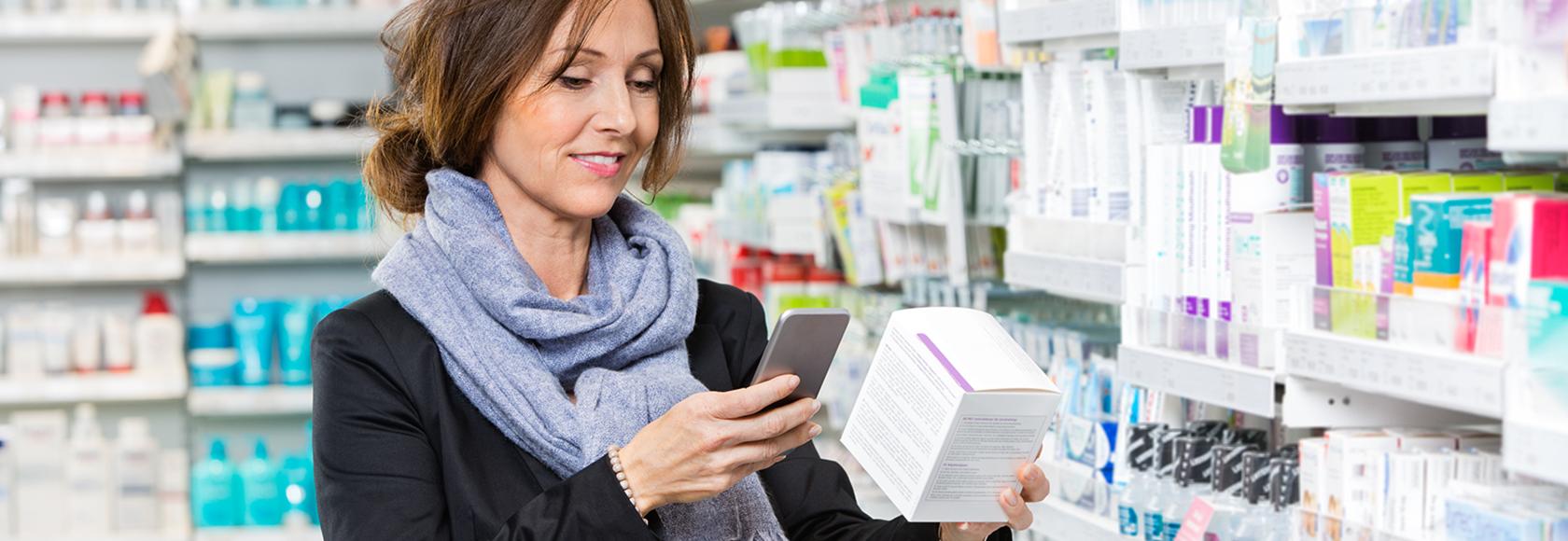 Kobieta w aptece wczytuje kod z opakowania leku