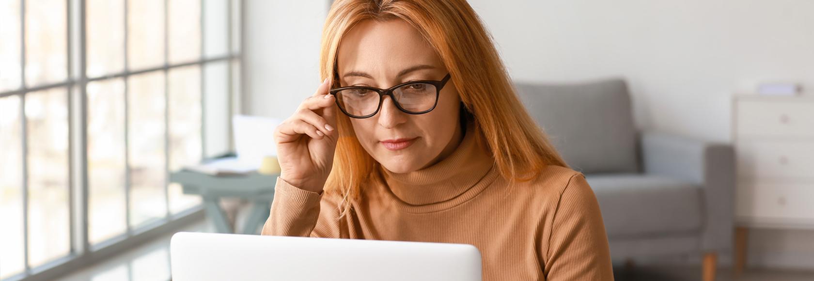 Kobieta w beżowym golfie przed komputerem