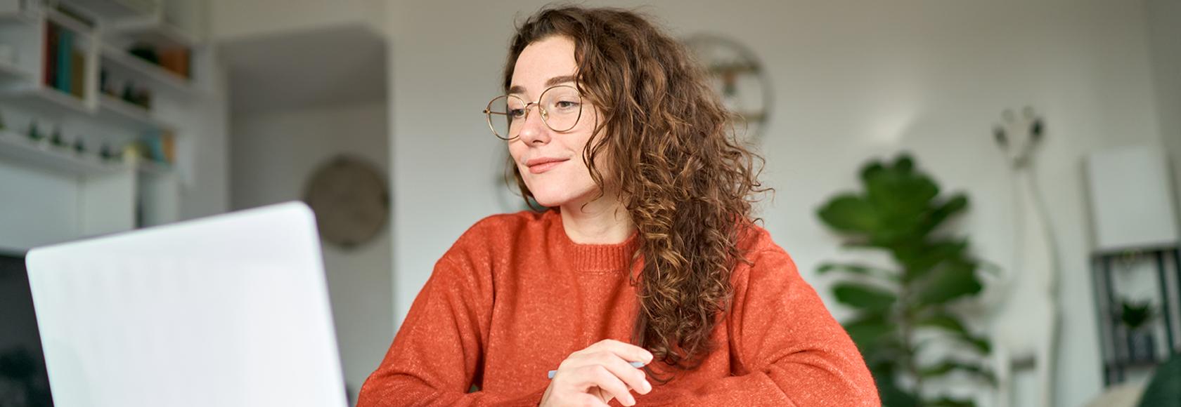 dziewczyna z długimi kręconymi włosami przed laptopem