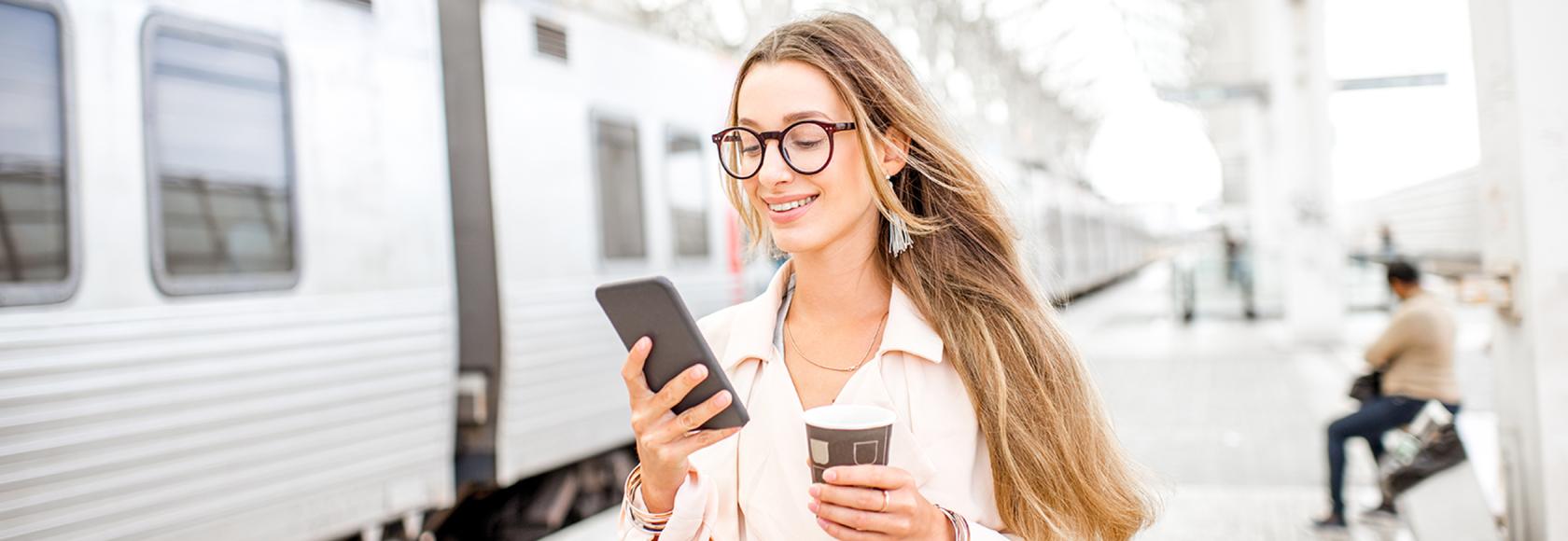 dziewczyna z długimi włosami na peronie z komórką w ręku
