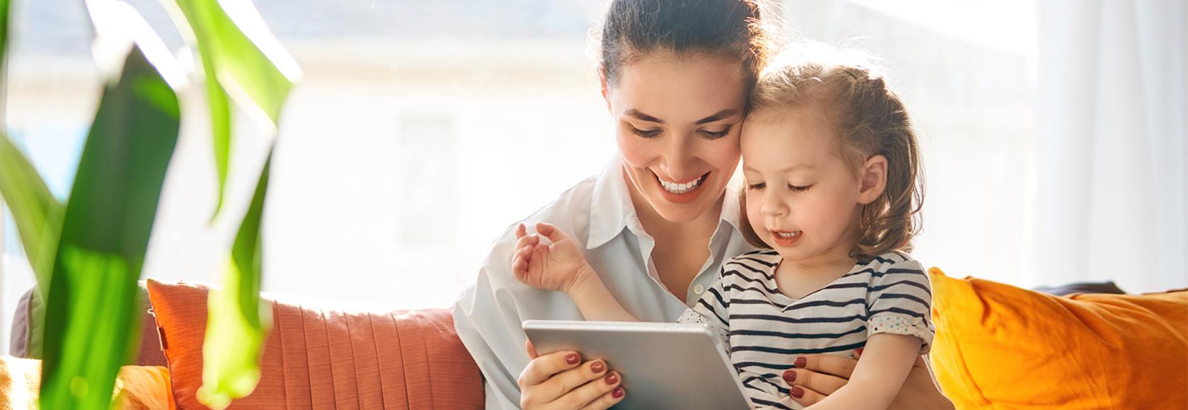 Mama z 2letnim dzieckiem na kanapie, trzyma tablet