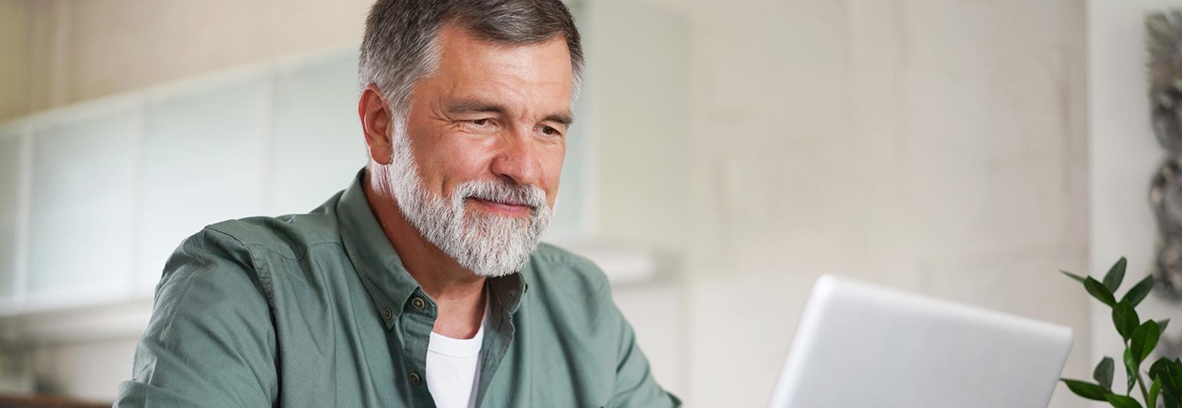pan z siwą brodą przed komputerem
