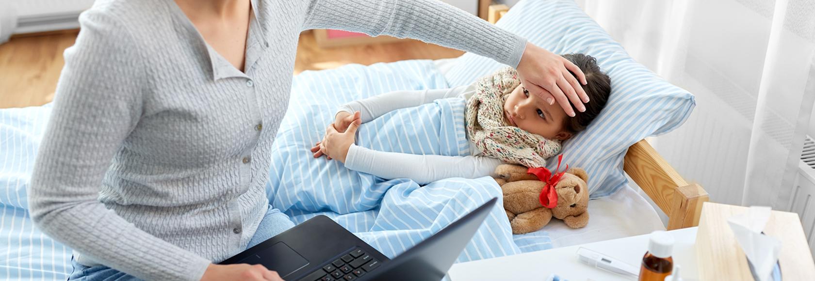 Matka sprawdza czolo córki i ma otwarty kompuer na kolanach