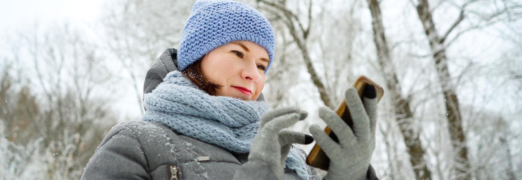 dziewczyna w czapce i kurtce na spacerze z komórką w reku