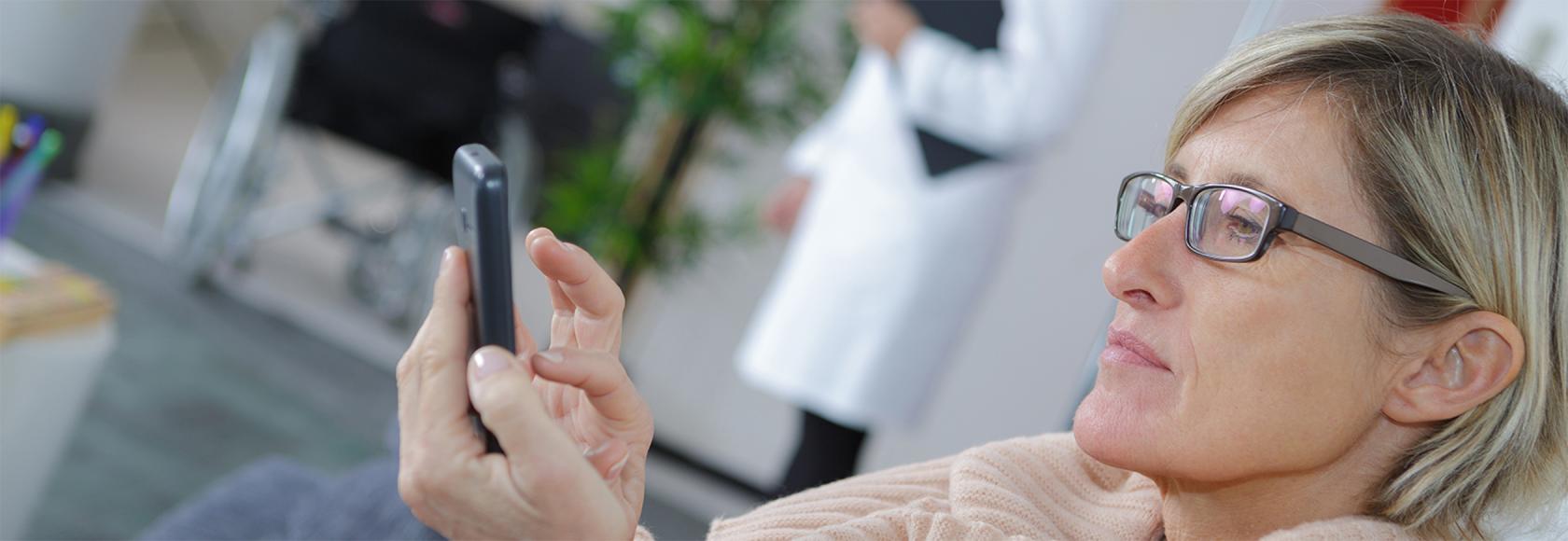 Pani w przychodni patrzy na komórkę