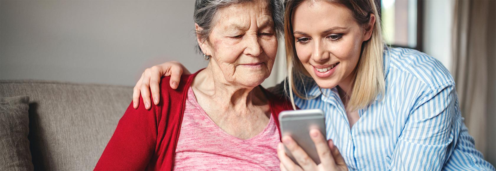Mloda kobieta pokazuje starszej cos na telefonie