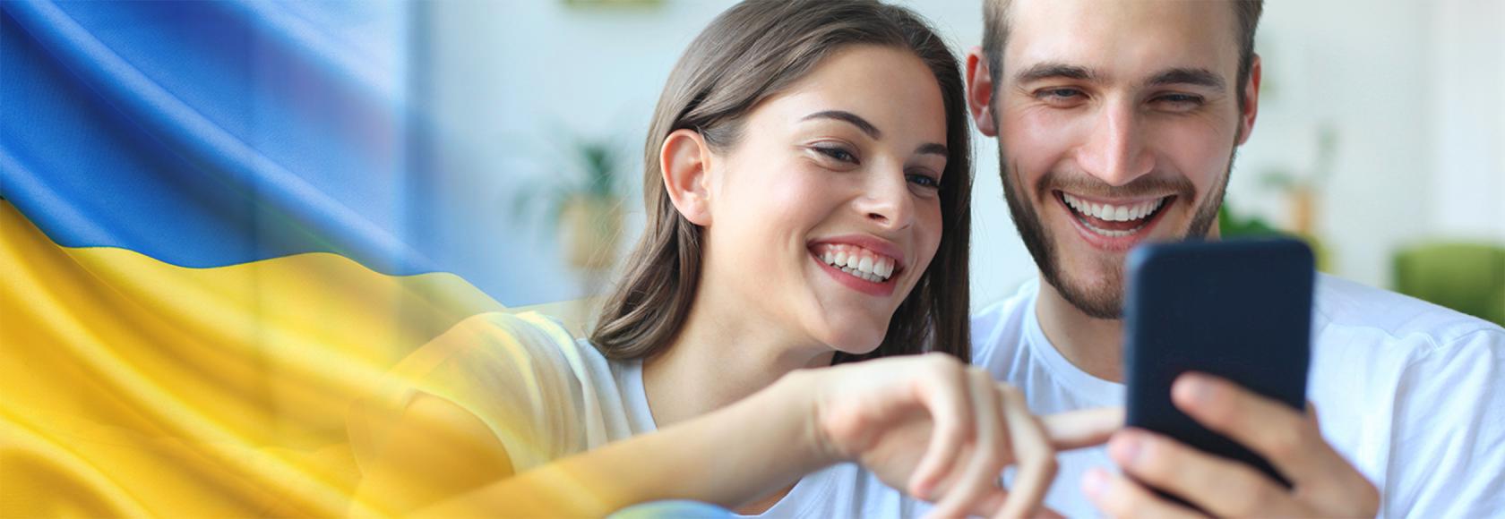 młoda para patrzy na komórkę, którą trzyma chłopak ukr