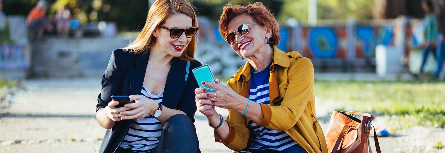 dwie panie w średnim wieku z komórkami, coś sobie tłumaczą