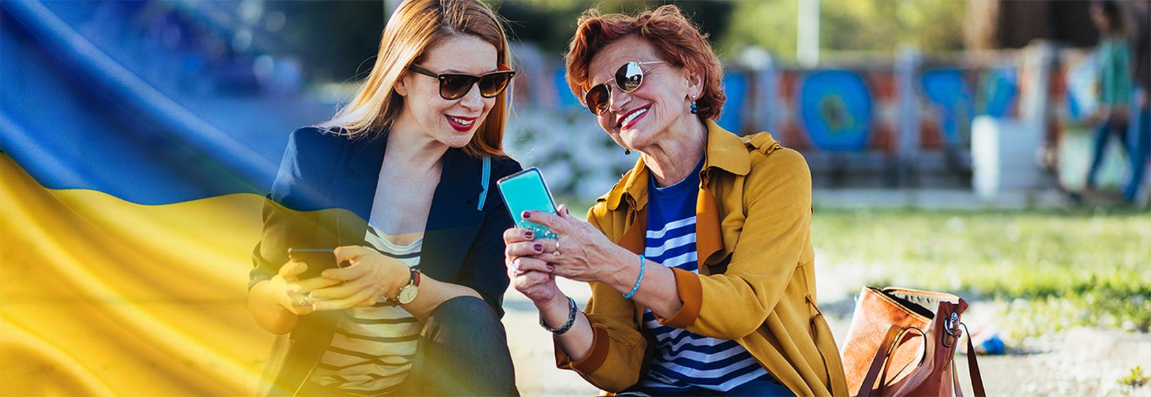 dwie panie w średnim wieku z komórkami, coś sobie tłumaczą ukr