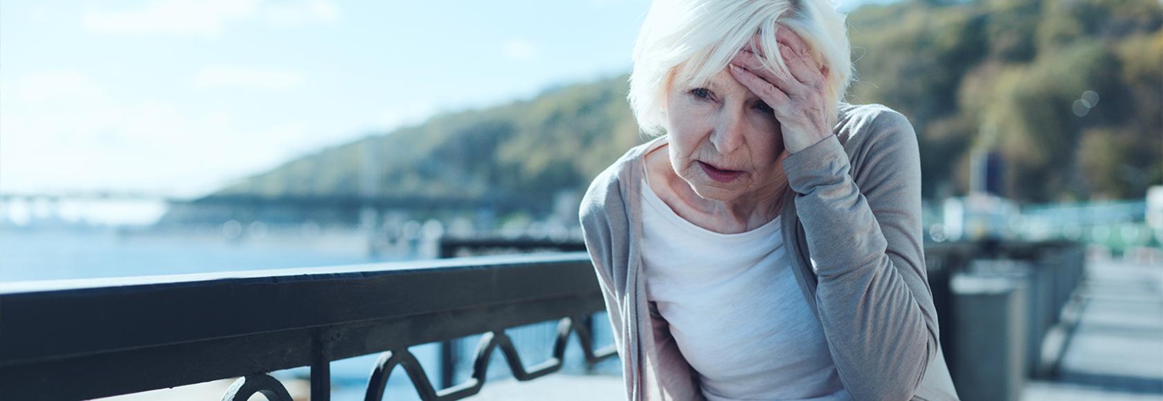 Starsza pani trzyma się za głowę