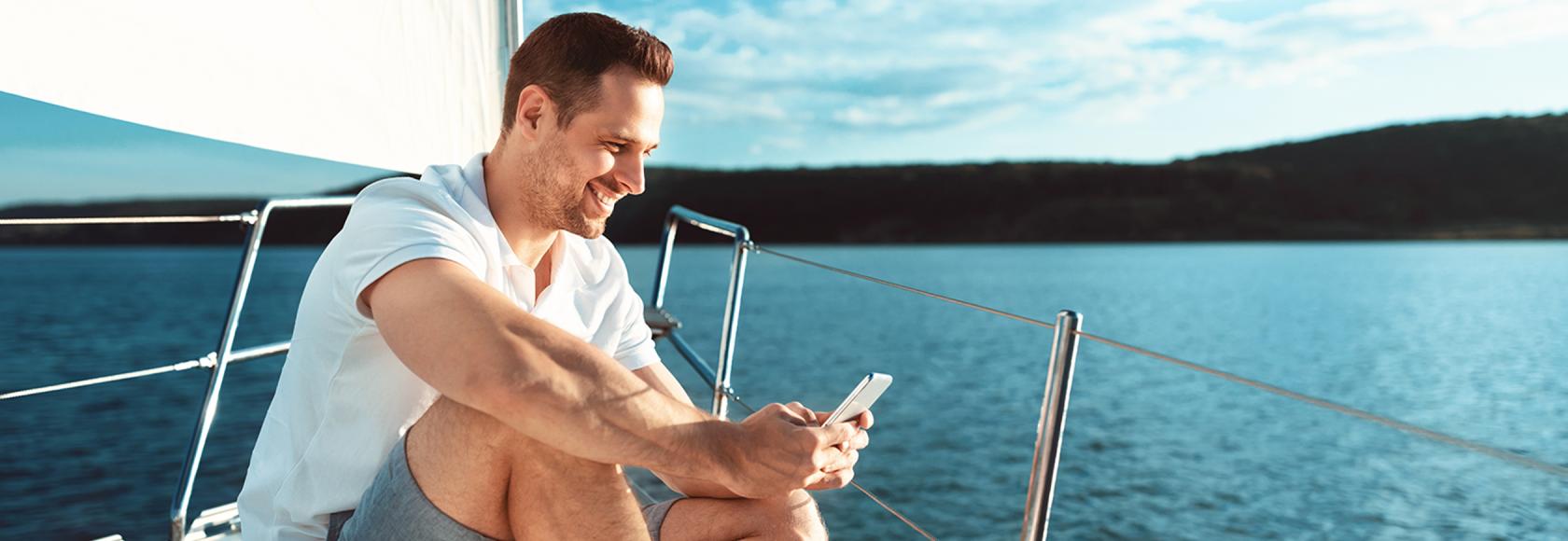 mężczyzna na łodce z komórką