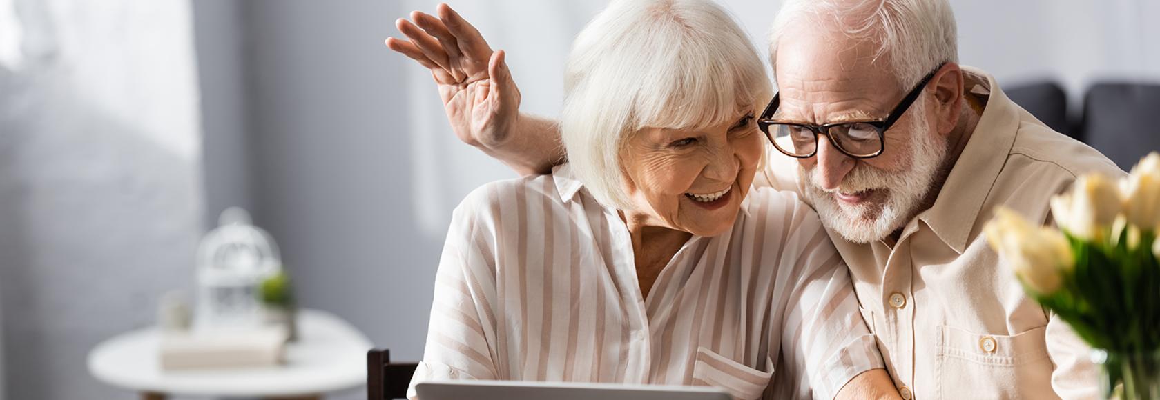 starsza para przy laptopie na kanapie