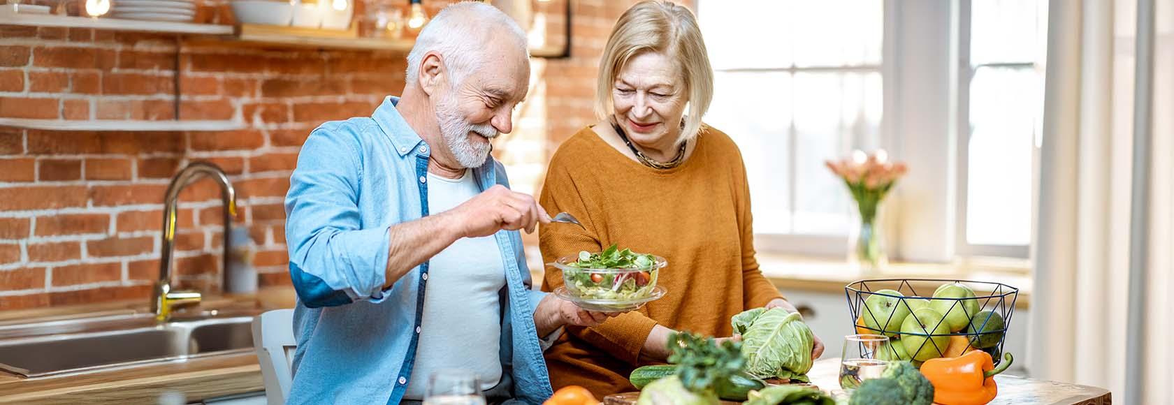 kobieta i mężczyzna w wieku senioralnym przygotowują posiłek