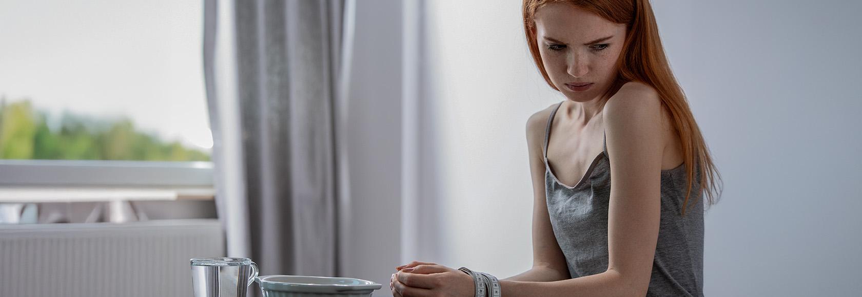 kobieta siedzi przy pustym talerzu