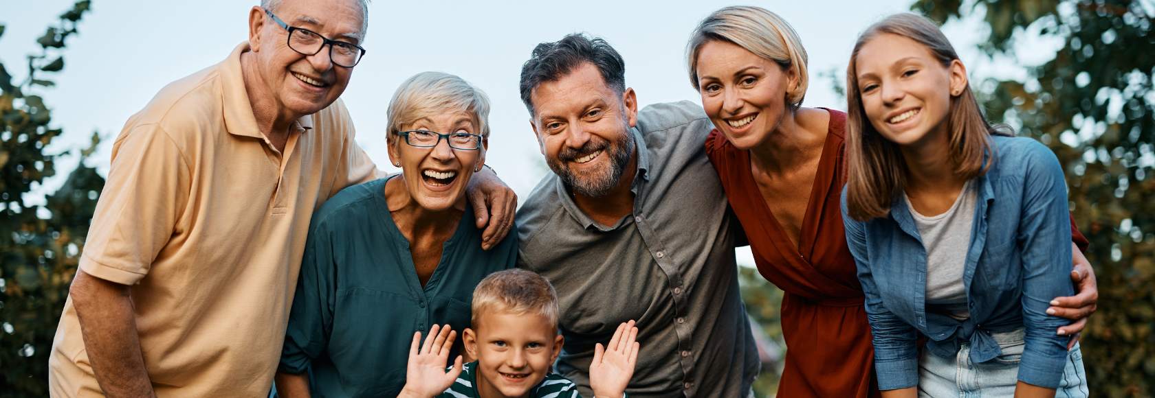 Uśmiechnięta rodzina pozuje do zdjęcia - dziadek i babcia, tata i mama, syn i córka