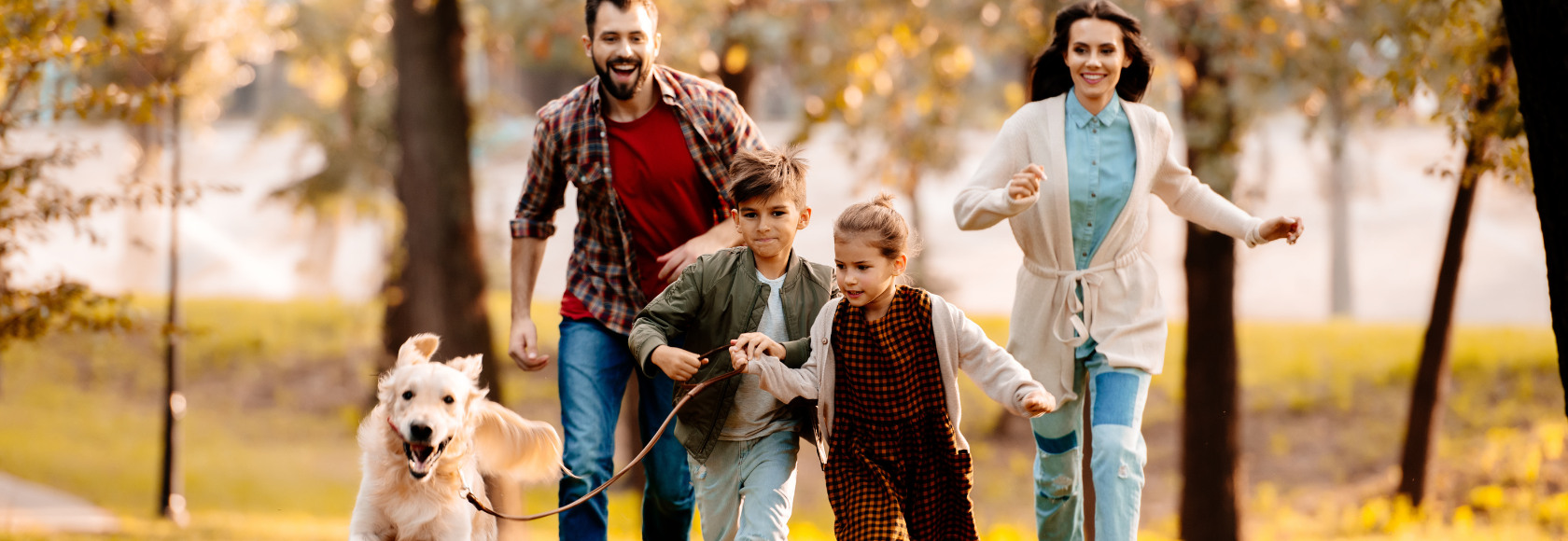 Rodzina biegnie po parku z psem