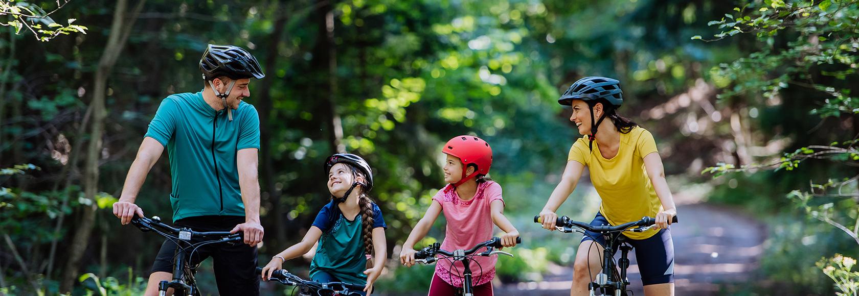 rodzice z dwójką dzieci na rowerach