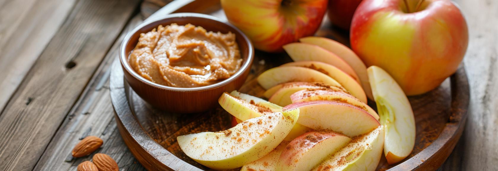 talerz z pokrojonymi jabłkami i pastą w miseczce