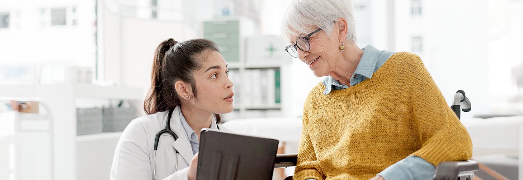 lekarka rozmawia ze starszą kobietą na wózku