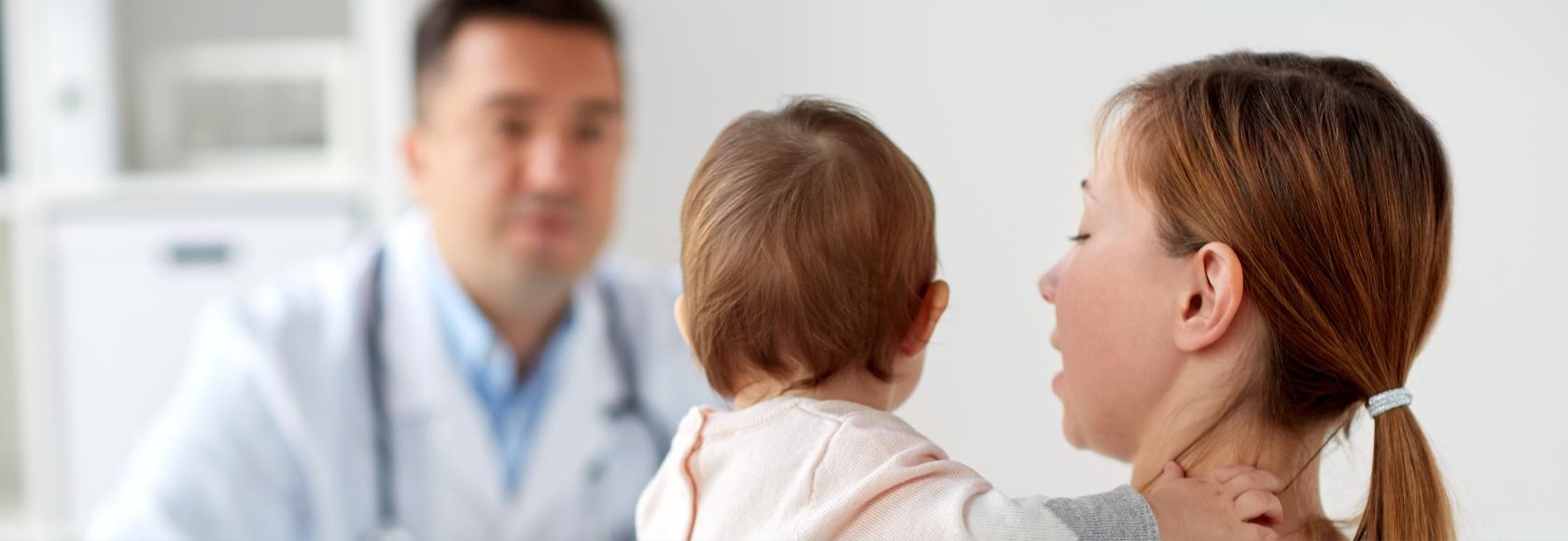 Matka  z dzieckiem na rękach u lekarza